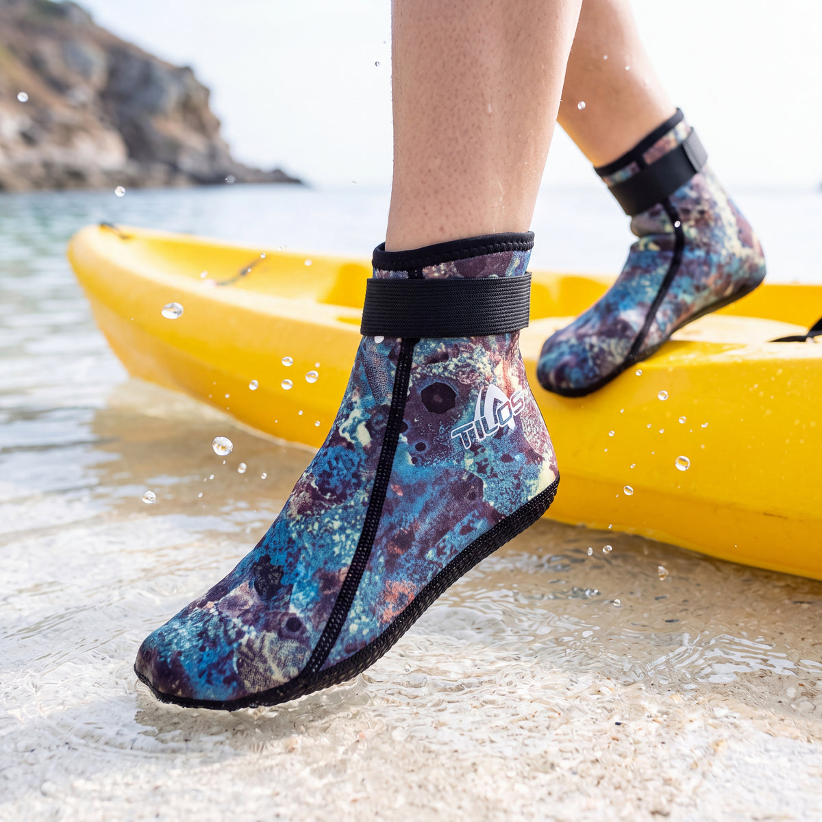 Kayaker stepping out of a kayak into clear shallows wearing the green camo Tilos 2mm Mid-High Top Socks with Velcro Straps