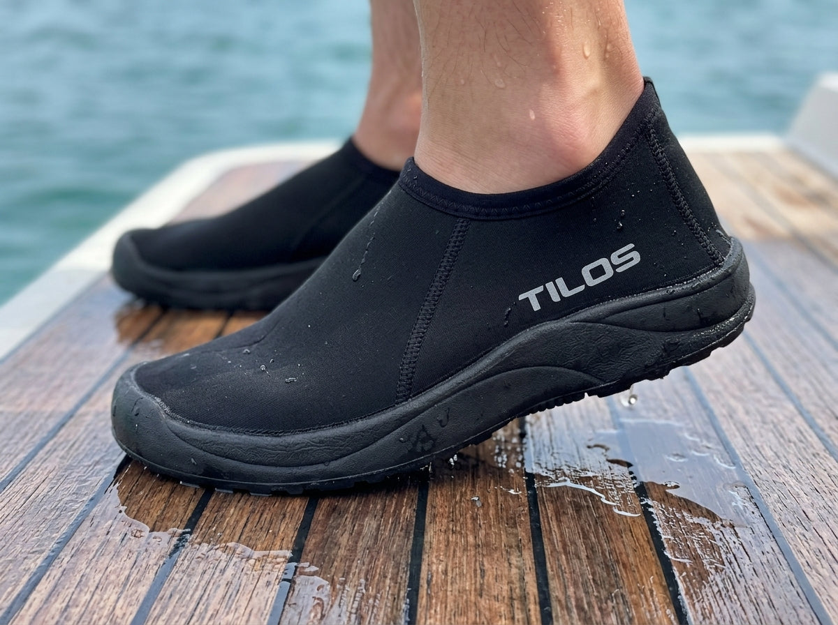 Snorkeler wearing the Tilos 3mm Low Cut Molded Sole Beach Boot on a wet teak boat deck