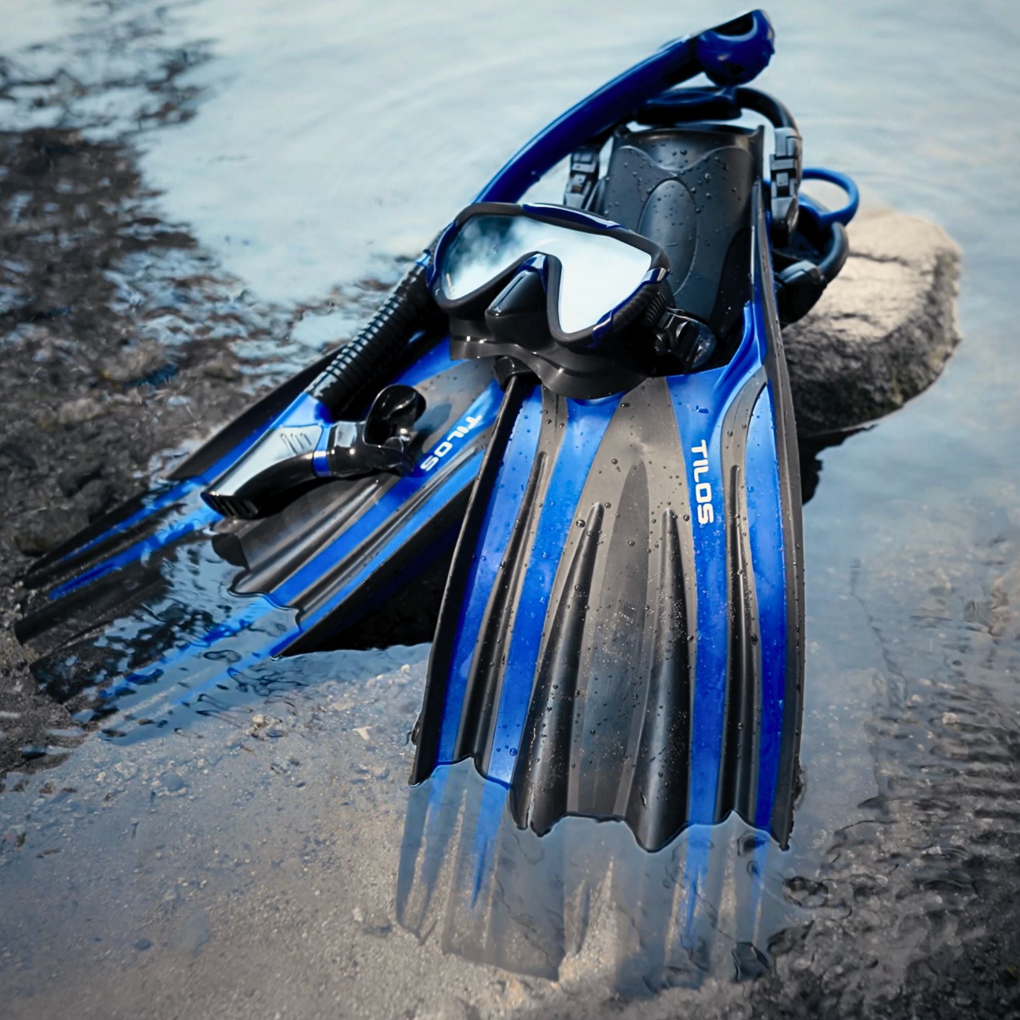 Diver carrying Tilos Forager Open Heel Diving Fins fins out of the water