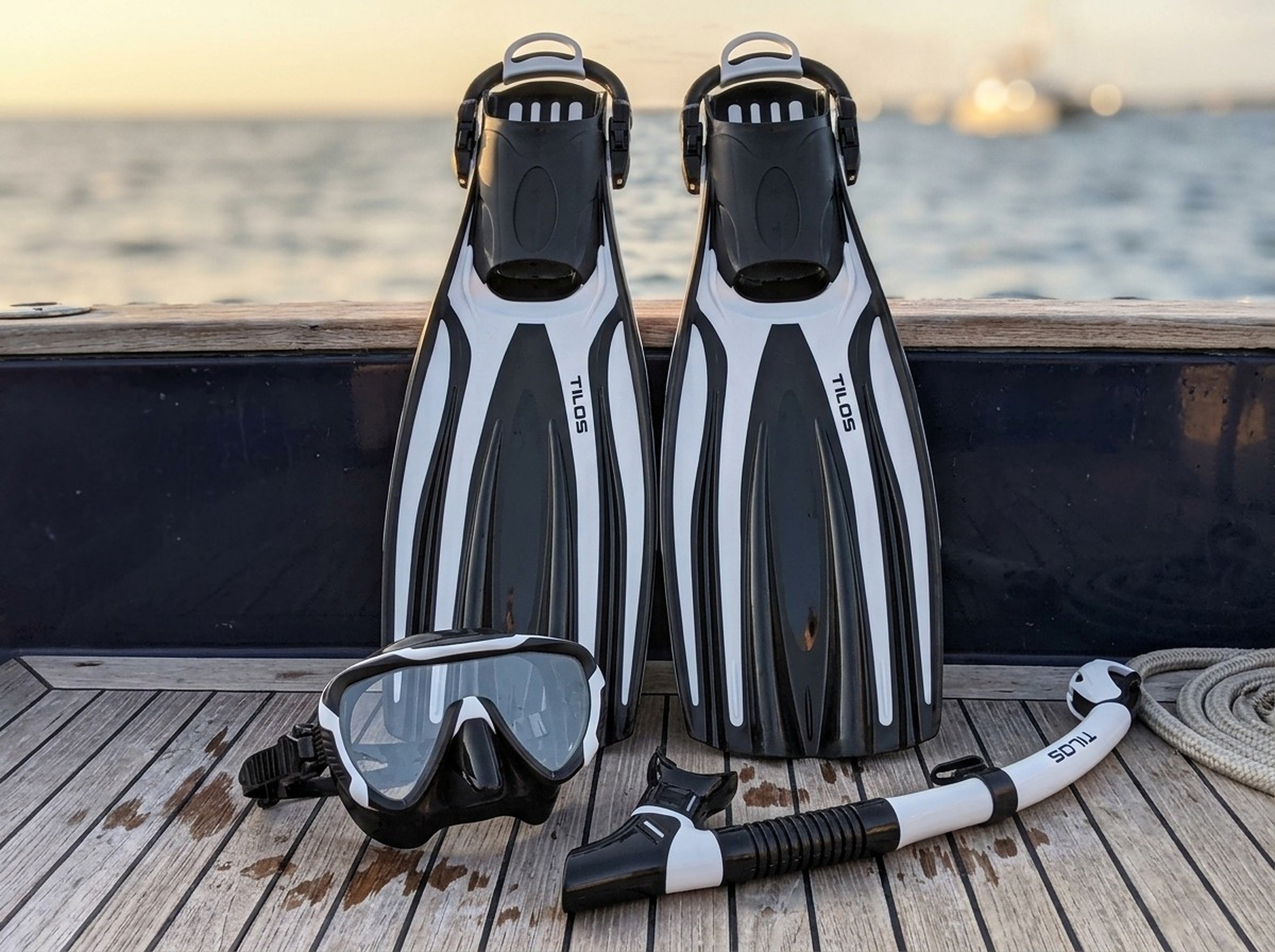 Snorkeler using the Tilos Morphi Mask, Orion Snorkel and Forager Fins Set in Black/White — sunset deck
