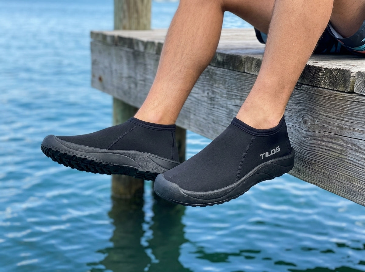 Diver wearing the Tilos 3mm Low Cut Molded Sole Beach Boot standing on a wooden dock by the water