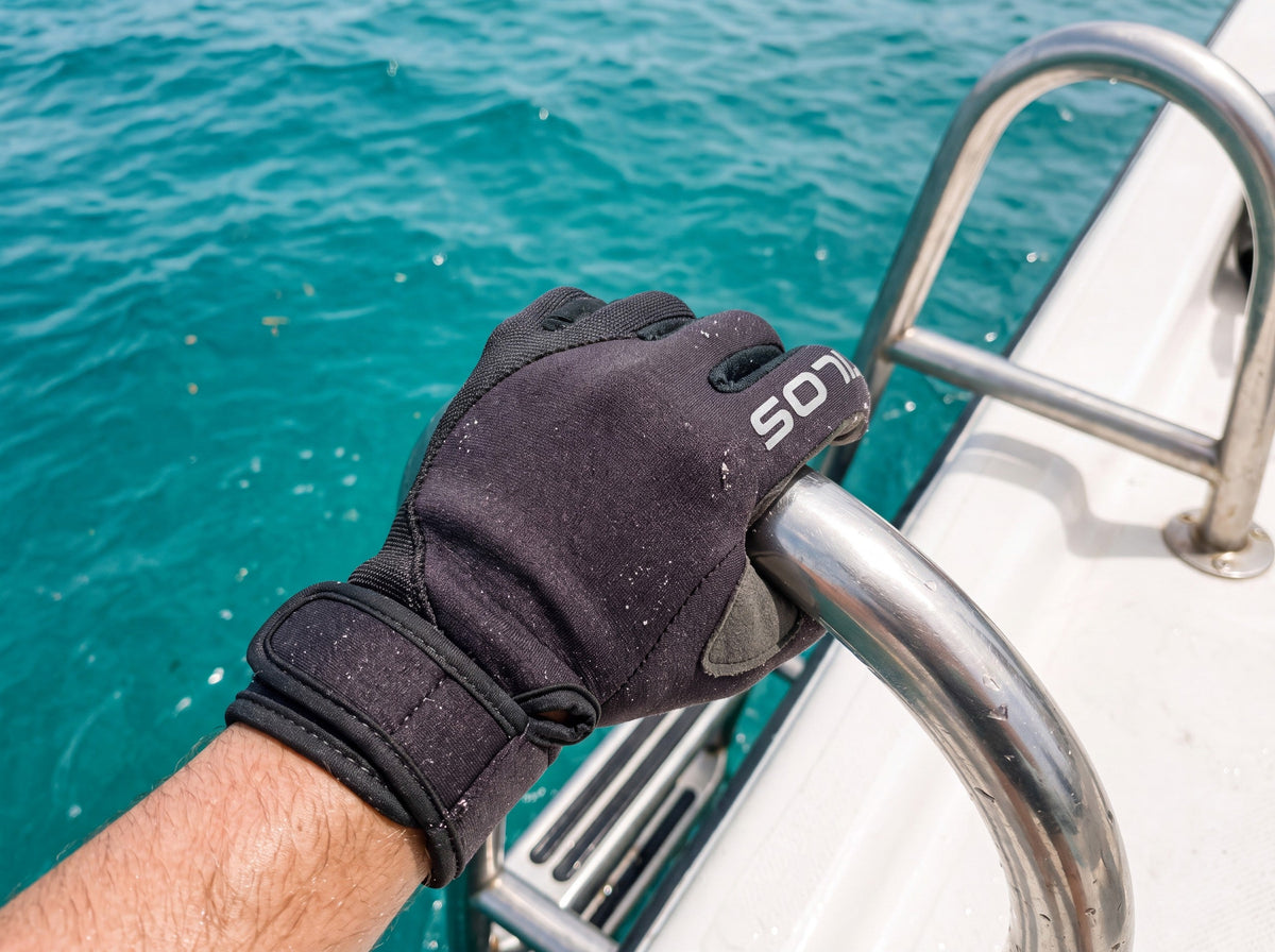 Diver in black Tilos 1.5mm Tropical-X Mesh Gloves gripping a stainless dive-boat ladder rail at the waterline