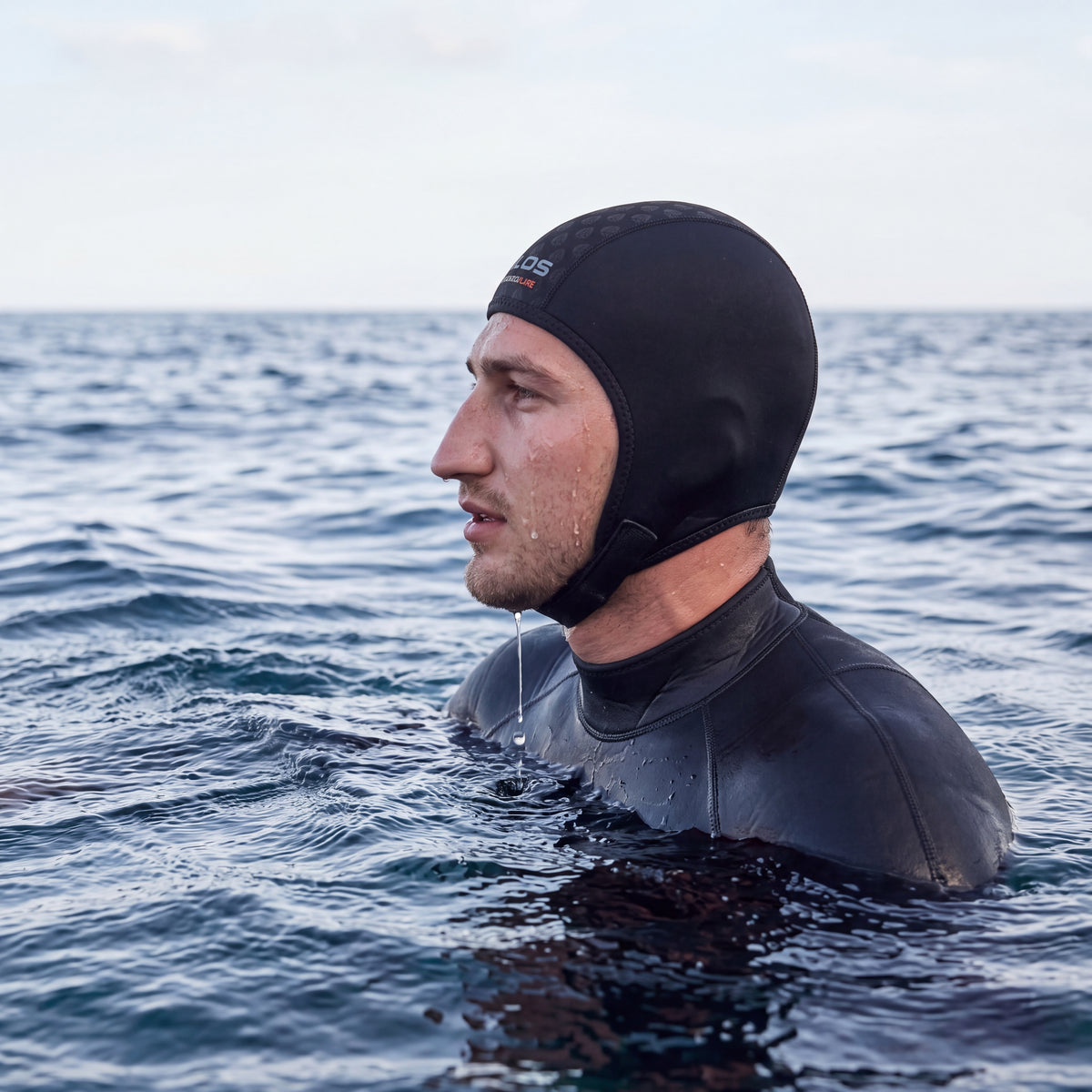 Snorkeler at the surface in side profile wearing the Tilos 1mm Thermoflare Chin Strap Beanie in black