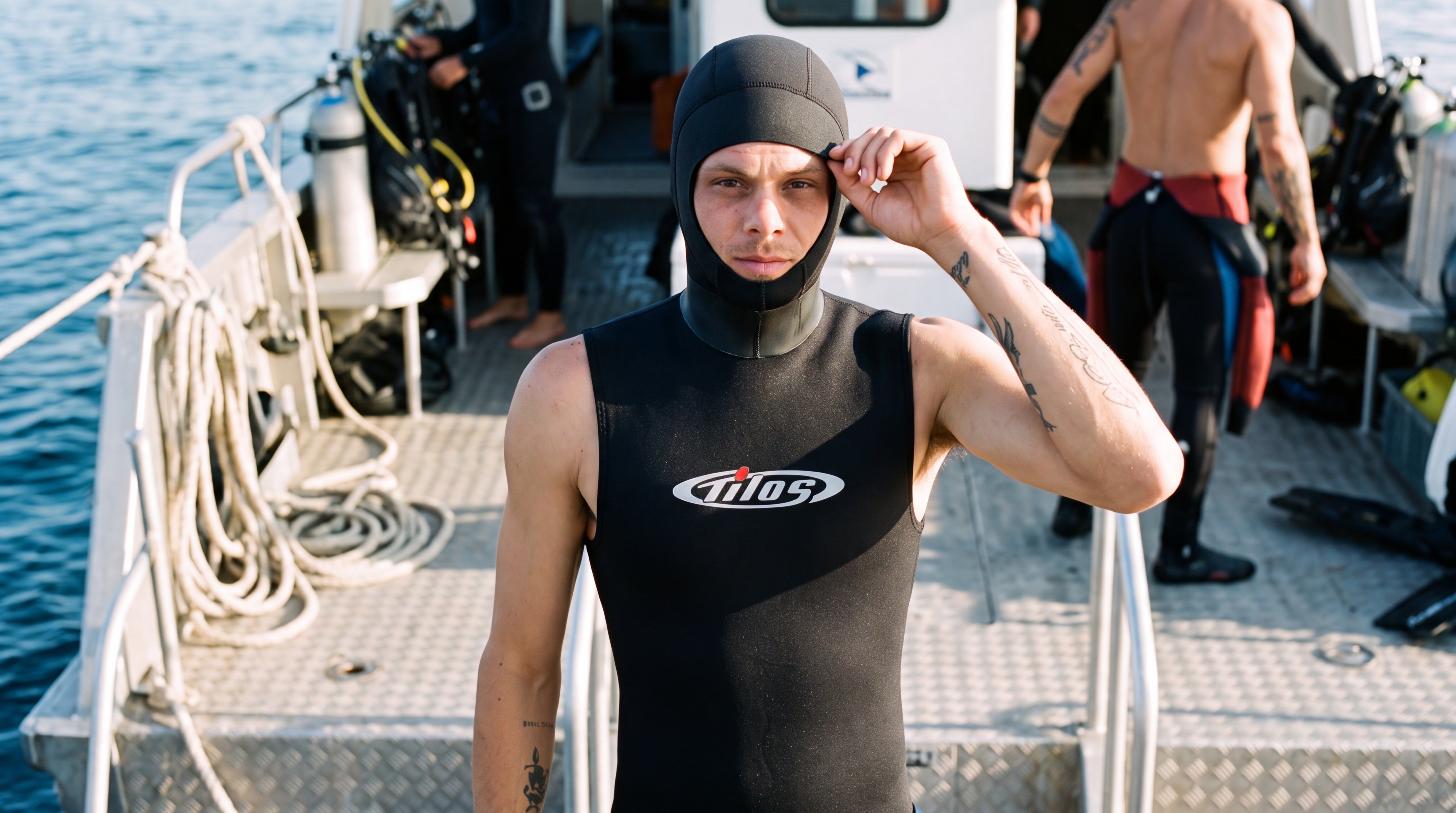 Freediver on a dive boat deck pulling up the hood of the Tilos 5/3mm Superstretch Hooded Vest before entry