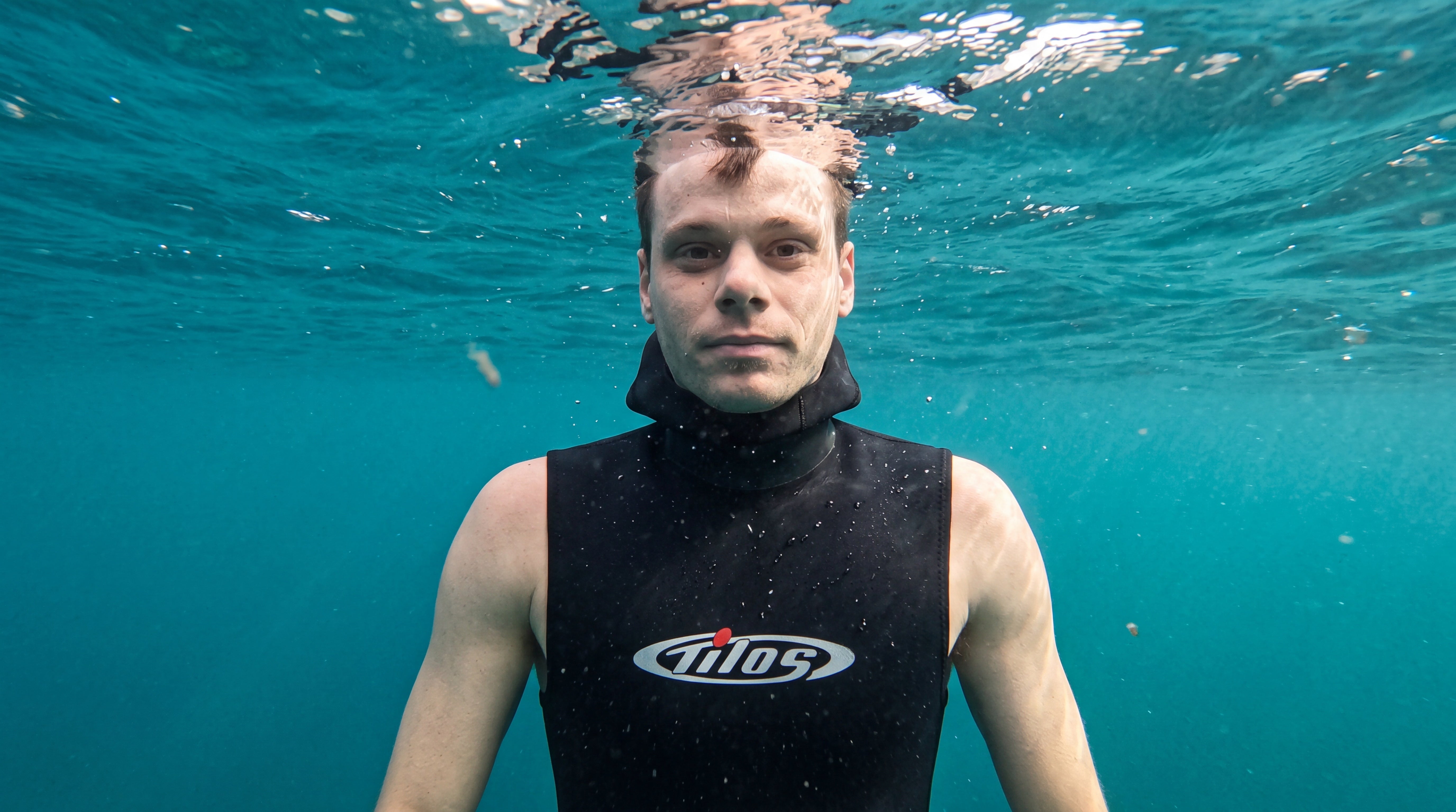Freediver floating at the ocean surface wearing the Tilos 5/3mm Superstretch Hooded Vest after a dive
