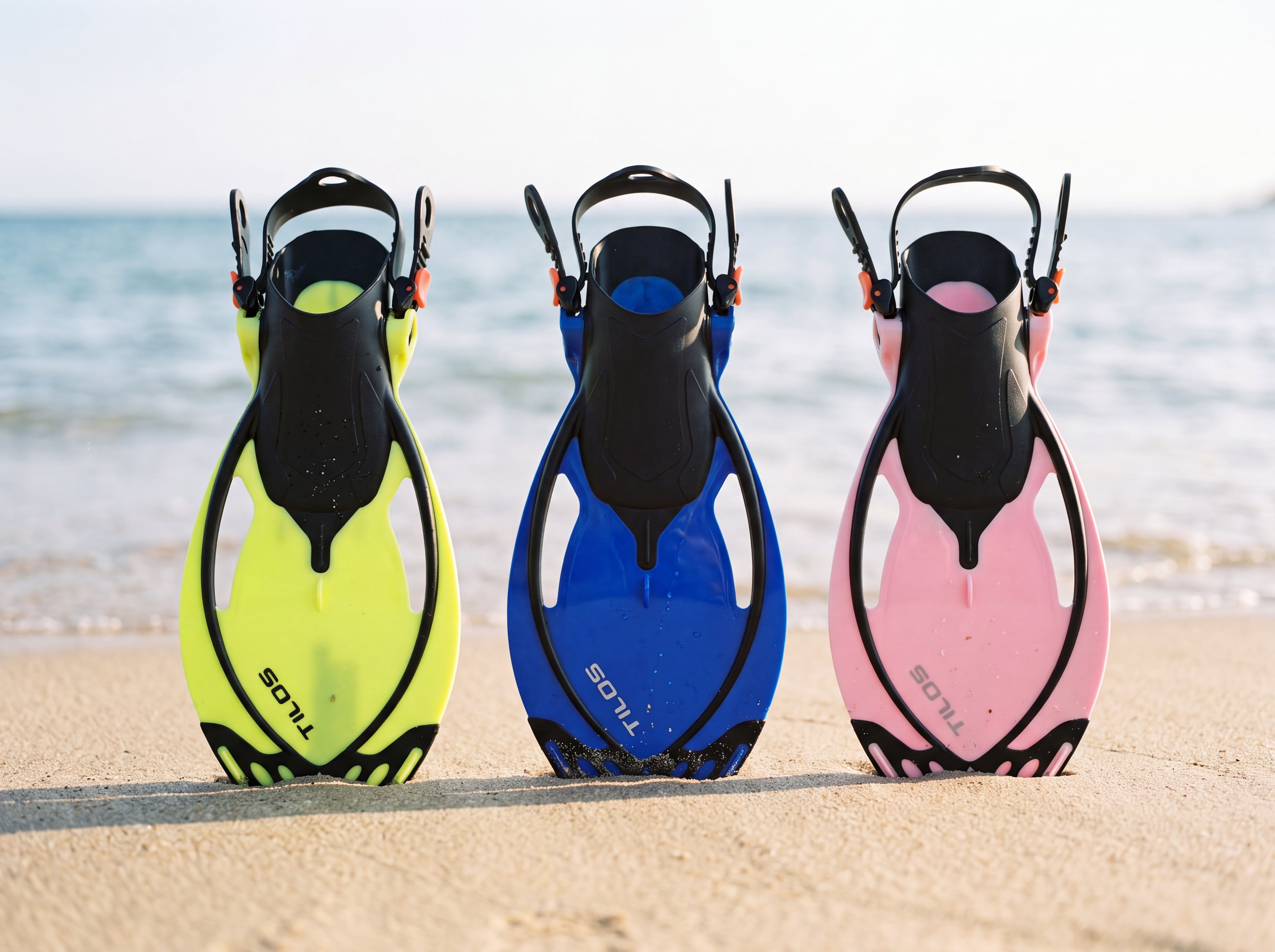 Tilos Vulcan Jr kids snorkel fins in yellow blue and pink on the beach